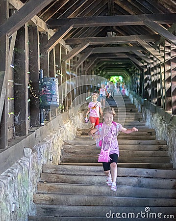 SIGHISOARA, ROMANIA - 1 JULY 2016: Girls running on The Scholars' Stairs, built in 1642 in Sighisoara, Romania Editorial Stock Photo