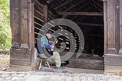 The street guitar player plays the guitar near the entrance to the tunnel, leading to the old town of Sighisoara in Romania Editorial Stock Photo