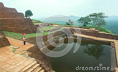 Lonely woman watching ruins of the ancient Sigiriya city with water pool and archeological area Editorial Stock Photo