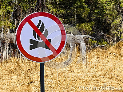 Sign ban bonfires on the background of forest and dry grass and trees. Stock Photo