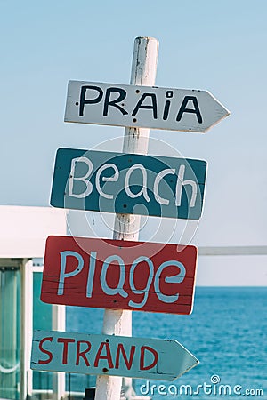 Sign on a beach in Algarve, Portugal translating beach in various languages including, Portuguese, English, French and Dutch Stock Photo