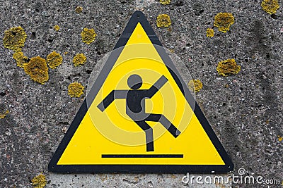 Sign beware slippy on wall Stock Photo