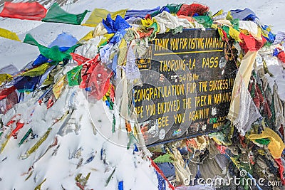 The sign with buddhist prayer flags at Thorong La mountain in Nepal Editorial Stock Photo