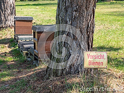 Sign caution bees in the park in german Stock Photo