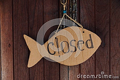 Sign is closed in the form of fish from cardboard. Hanging on the door on the rope Stock Photo