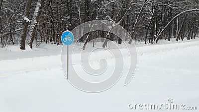 Sign `Cycle trail` against the background of snow-covered forest. Stock Photo