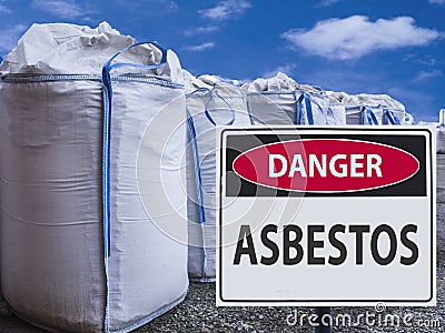 Sign danger asbestos and a stack of big bags of asbestos. Stock Photo