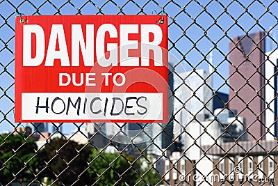 Sign danger due to homicides hanging on the fence Stock Photo