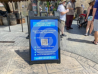 A sign explaining the virtual line system at Universal Studios outside the Hagrid`s Magical Creatures Ride Editorial Stock Photo