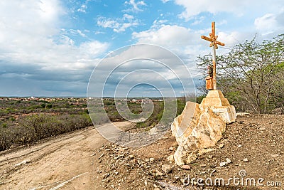 A sign of faith, a cross, beautiful clouds in a dry road at Cariri Paraiba Brazil Countryside Stock Photo