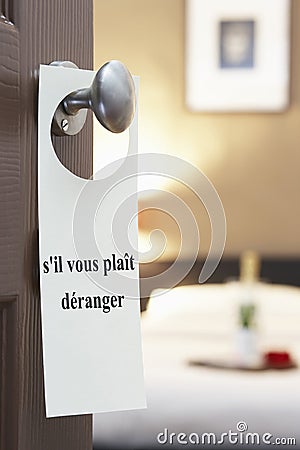 Sign with French text s'il vous plait deranger (please disturb) hanging on hotel room door Stock Photo