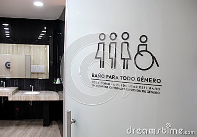 Sign of inclusive bathrooms for all genders in Spanish combating discrimination trans women and men, people with disabilities Stock Photo