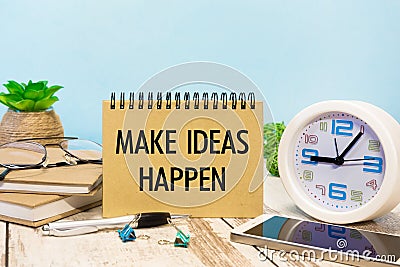 A sign with the inscription MAKE IDEAS HAPPEN on the table Stock Photo