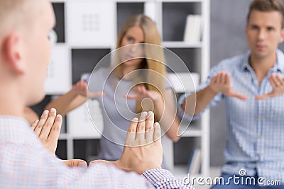 Sign language learners repeating new sign after their teacher Stock Photo