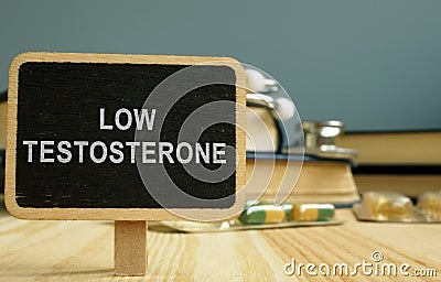 Sign low testosterone and book on wooden surface Stock Photo