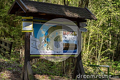 Sign with map of national park standing in the forest on sunny day Stock Photo