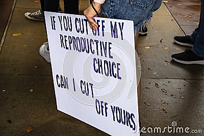 Sign reading If you cut off my reporductive choice can I cut off yours held by woman in shorts at protest Editorial Stock Photo