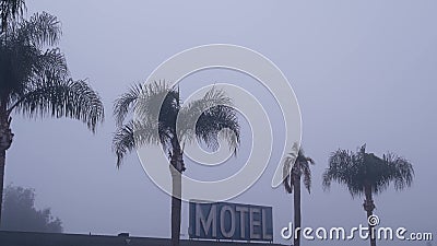 Sign of road motel or hotel, foggy misty weather California, USA. Palm trees. Stock Photo