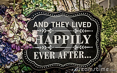 Sign saying And they Lived Happily Ever After surrounded by hydrangeals and ferns - Wedding Stock Photo