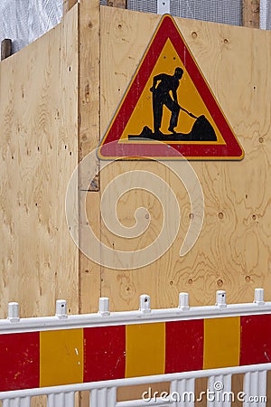 A sign signifying renovation work hangs on the wooden wall of the building. Stock Photo