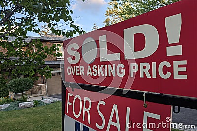 Sign sold over asking price for sale in front of detached house in residential area Stock Photo