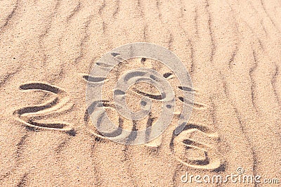 Sign 2016 and sun written on sandy beach. Summer travel concept Stock Photo