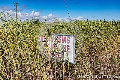 sign Trespassing fine will be executed in a field at the coast in Galveston, Texas Stock Photo