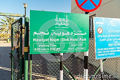 Sign with visiting time all ingresso di Hawiyat Najm Sink hole park, in english and arabic language. Editorial Stock Photo