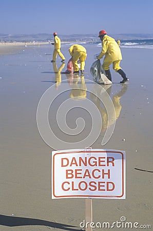 A sign warning ï¿½Dangerï¿½ after an oil spill closed Huntington Beach, as cleanup workers remove oil from the California Editorial Stock Photo