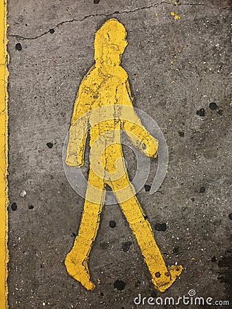 Sign of a yellow person walking on the floor in a parkinglot Stock Photo