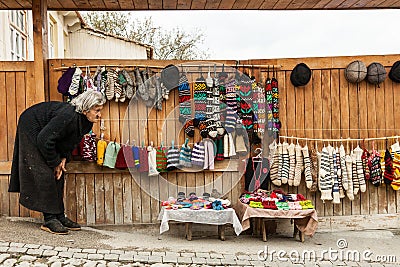 Local woman selling hand made wool products as a souvenir on a street in Signagi, Georgia Editorial Stock Photo