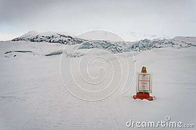 `Unguided trail` sign hanging on a safety cone on a path at Matanuska Glacier. Stock Photo