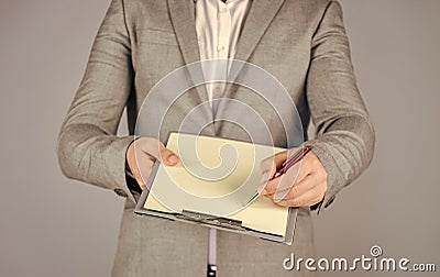 Signing the contract. Pleasant cheerful handsome realtor holding folder. bearded man working in office. Portrait of Stock Photo