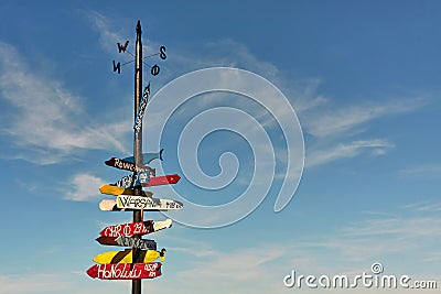 Signpost with colorful directional signs and distances to different towns Stock Photo