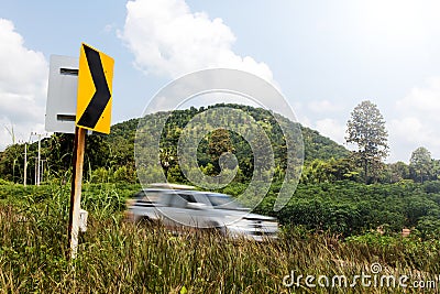 Signs curve with cars blurred hill. Stock Photo