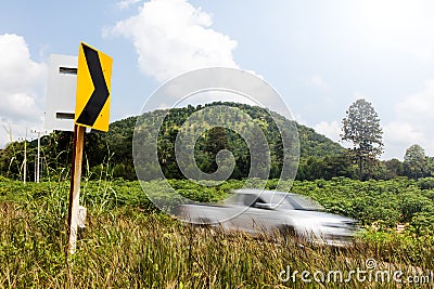 Signs curve with cars blurred hill. Stock Photo