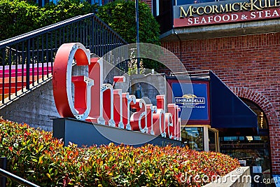 Signs for Ghirardelli with Seafood and Steak restaurant and rainbow staircase Editorial Stock Photo