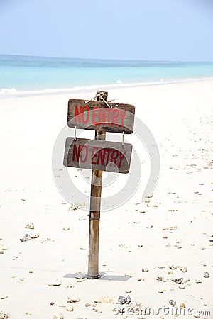 Signs no entry on beach with blue sea. Stock Photo