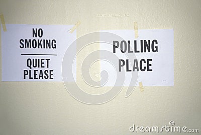 Signs taped to the wall in a polling place read No Smoking and Polling Place Stock Photo