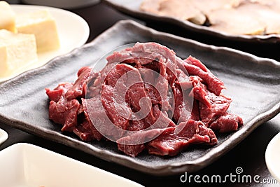 Silced beef heart with tofu on black plate in a hot pot meal Stock Photo