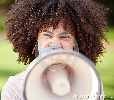 Silence becomes cowardice. a young woman screaming into a loudspeaker while protesting in the park. Stock Photo