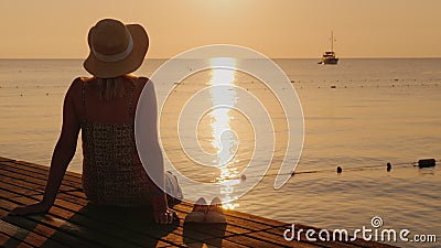 Silence and pacification in the early morning on the sea pier, the girl enjoys loneliness Stock Photo