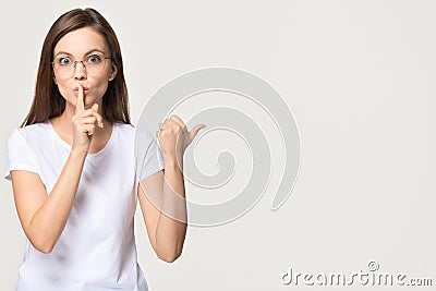 Silent girl holding finger on lips isolated on grey background Stock Photo