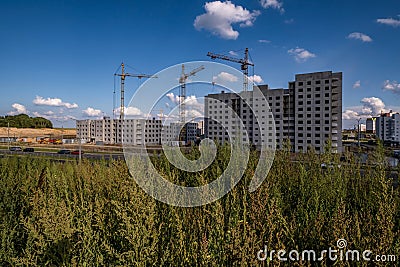 silhoette of tower cranes on construction site, providing housing for low-income citizens of third world countries Stock Photo