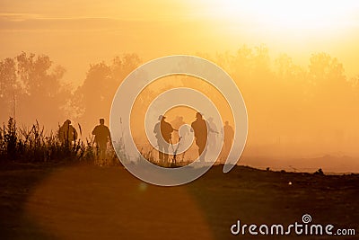 Silhouette action soldiers walking hold weapons the background is smoke and sunset. War, military and danger concept Stock Photo