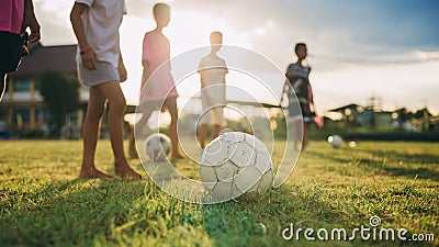 Silhouette action sport outdoors of diversity of kids having fun playing soccer football for exercise in community rural area unde Stock Photo