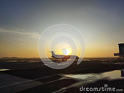Silhouette of an airplane parked in the airport apron area at sunrise Editorial Stock Photo