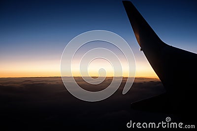 Silhouette airplane wing over the clouds Stock Photo