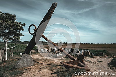 Silhouette of an anchor against a bright blue sky, symbolic of a memorial to lost sailors Stock Photo