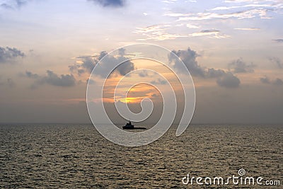 Silhouette of an anchor handling tug boat at oil field during sunrise Stock Photo